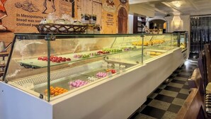 Une vitrine de boulangerie présentant diverses pâtisseries et un mur affichant des informations historiques.