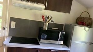A compact kitchen with dark wooden cabinets, a microwave, a refrigerator, and a small countertop. - Very quiet 2 br apartment - Pool, private backyard - close to beaches (La Garde)