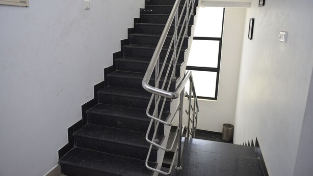Una escalera con barandilla metálica que lleva a una plataforma.