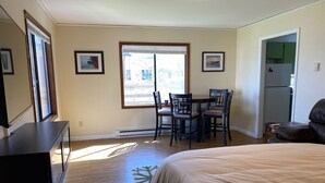 A bedroom with a bed, a desk, a chair, and a window. - Quaint Downtown Cottage (Astoria)