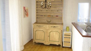 A kitchen with a wooden cabinet, a chandelier, and a window.