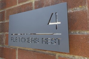 A house number sign with the text "4" and "FLETCHERS REST" on a brick wall. - Fletchers Rest (Whitby)