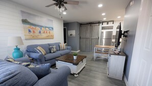 A modern living room with a sofa, coffee table, and a painting on the wall. - Perfect Family Beach Stay • Private Courtyard • Walk Everywhere (Ocean City)