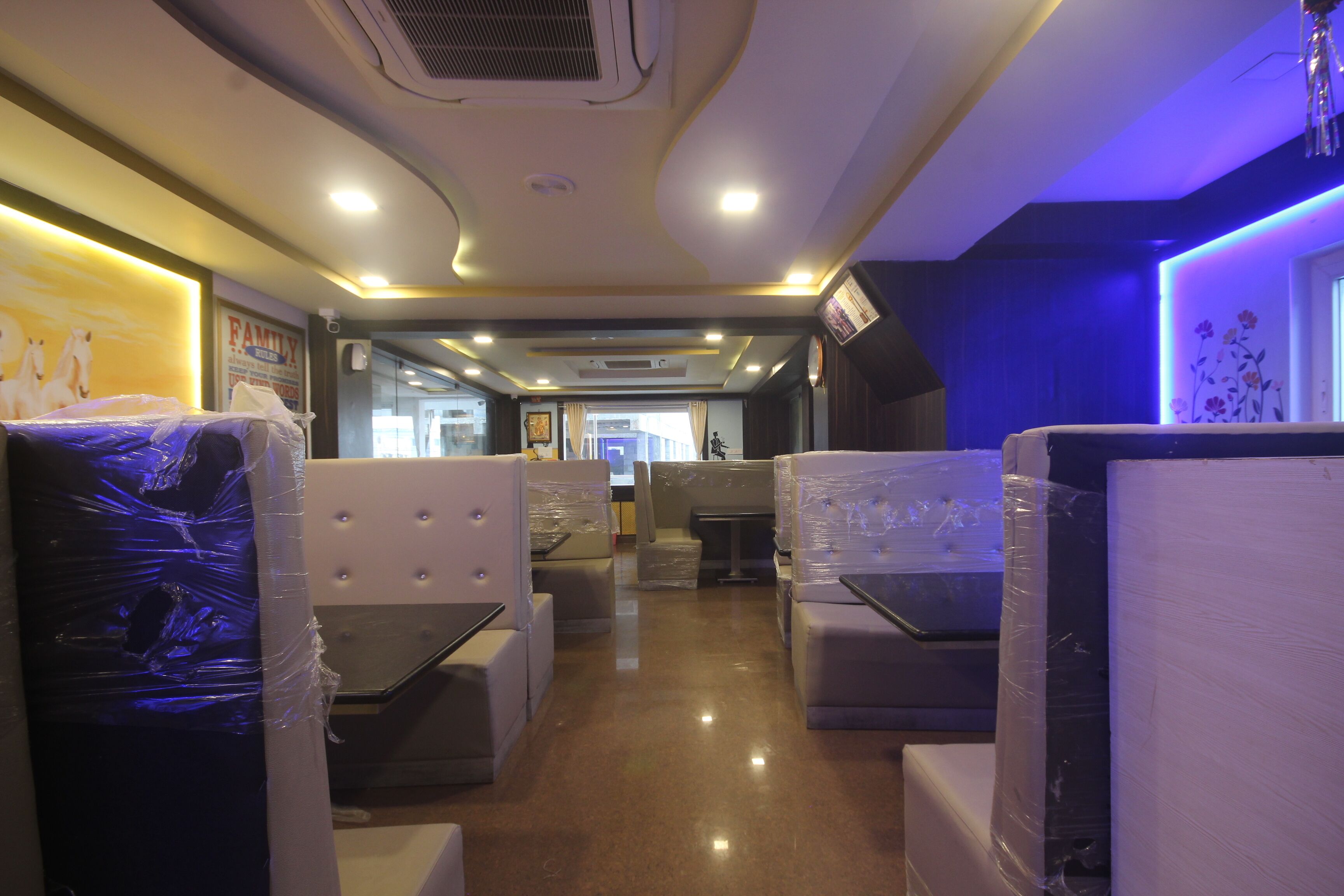 A train car interior with seating areas, overhead luggage compartments, and a central aisle.