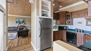 A kitchen with wooden cabinets, a stainless steel refrigerator, and a dishwasher.