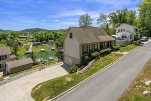 A residential area with houses, a road, and a lake.