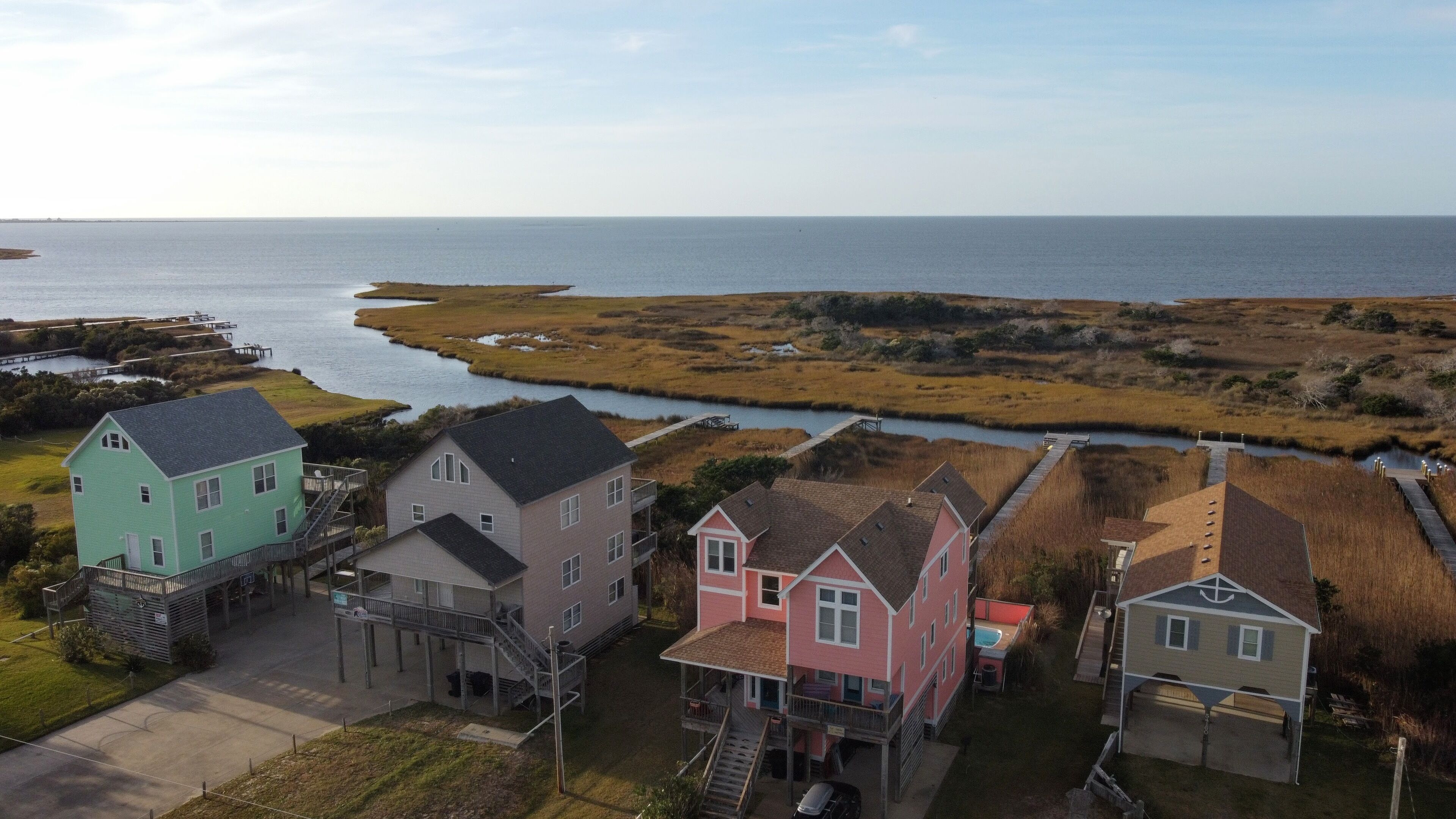 A coastal residential area with houses and a pier extending into the water.
