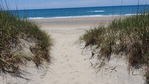 A sandy beach path leading to the ocean, surrounded by grass. - Amazing Sound Front, Ocean View Home with Pool, Spa and Dock (Frisco)