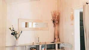 A minimalist bathroom with a wooden vanity, a mirror, and a small seating area. - Appartement Nature et Jardin (Eymoutiers)
