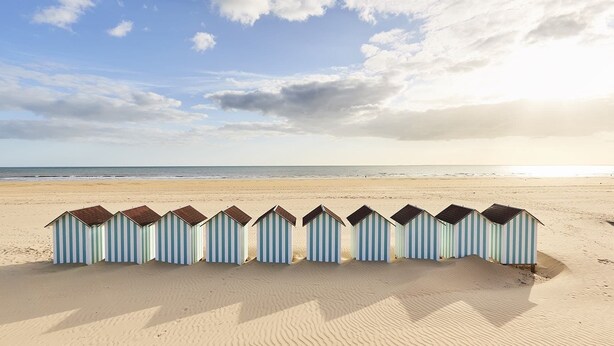 A row of beach huts aligned on a sandy beach with the ocean in the background. - Bel Appartement au Bord de L'océan (Saint-Jean-de-Monts)