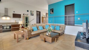 Una sala de estar moderna con sofá, mesa de centro y área de cocina.