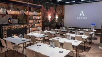 A conference room with multiple tables, chairs, and a presentation screen displaying 'ACCOR'.