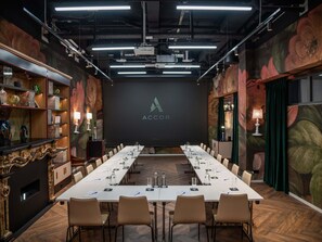 A conference room with a long table, chairs, and a projector screen displaying the ACCOR logo. - Aparthotel Adagio Zurich Center (Zürich)