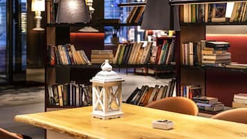 Eine Bibliothek mit Bücherregalen, einem Holztisch und einer weißen Laterne.