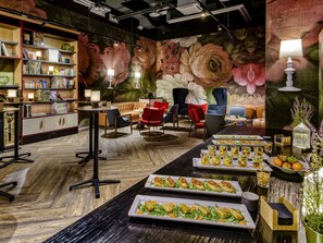 Un restaurant décoré d’une fresque florale, doté de meubles en bois et où l’on peut trouver une variété de plats sur les tables.