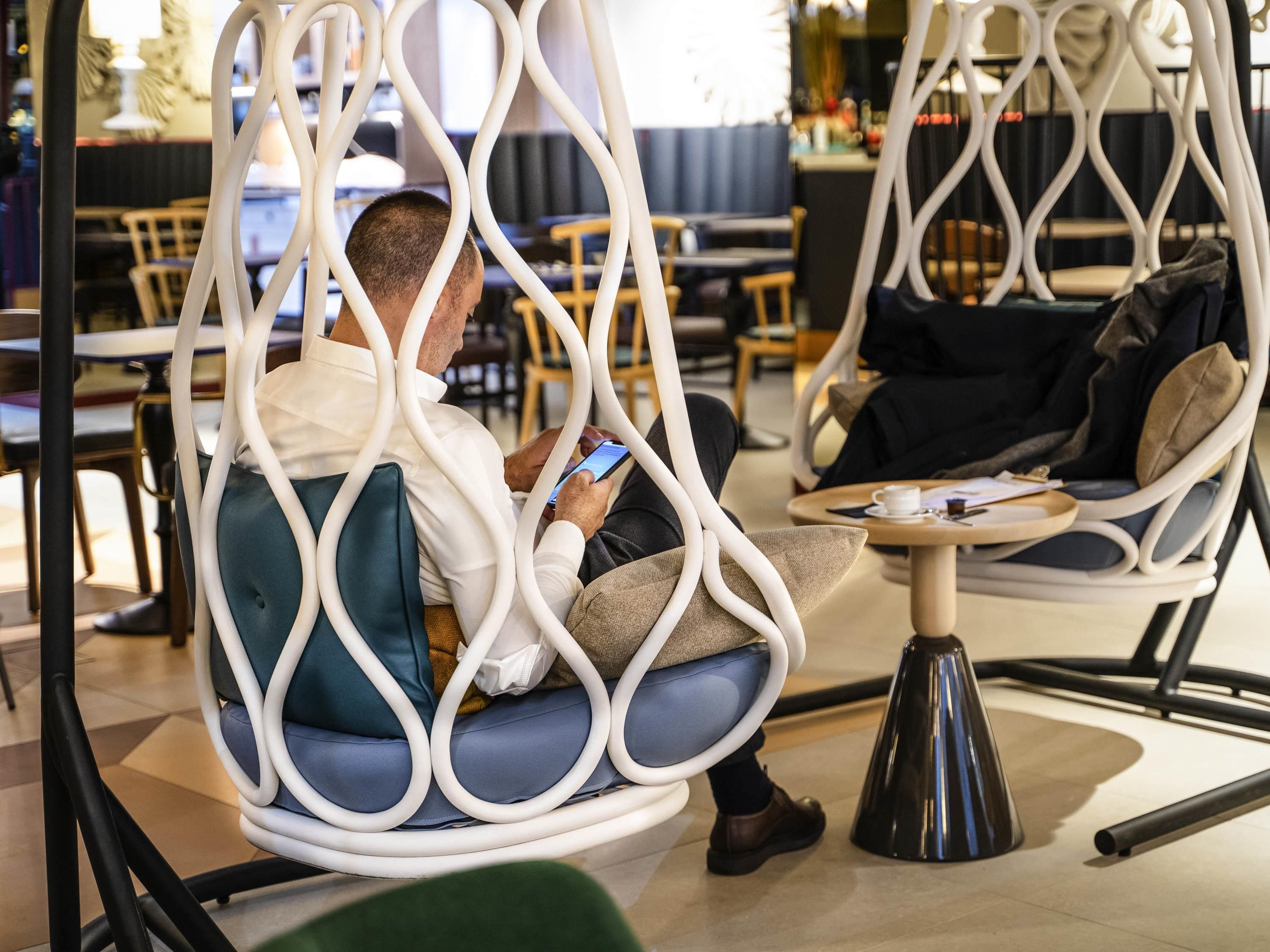 Een modern interieur met een zithoek, inclusief een opvallende, witte, gebogen metalen constructie.