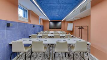 A conference room with a long table, chairs, a projector screen, and a whiteboard.