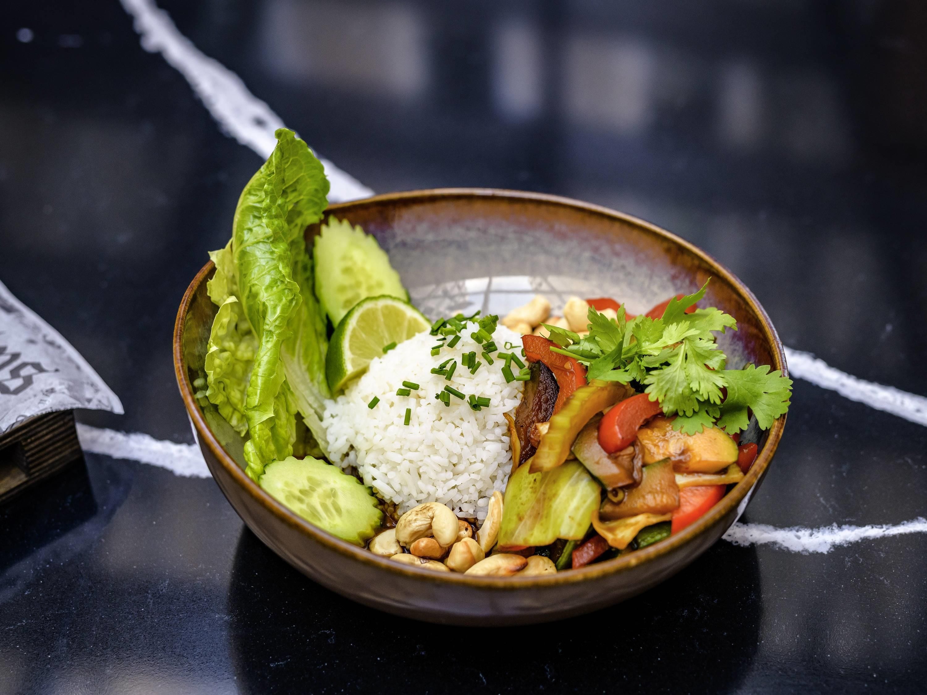 Un bol contenant un plat composé de riz, de légumes et de noix.