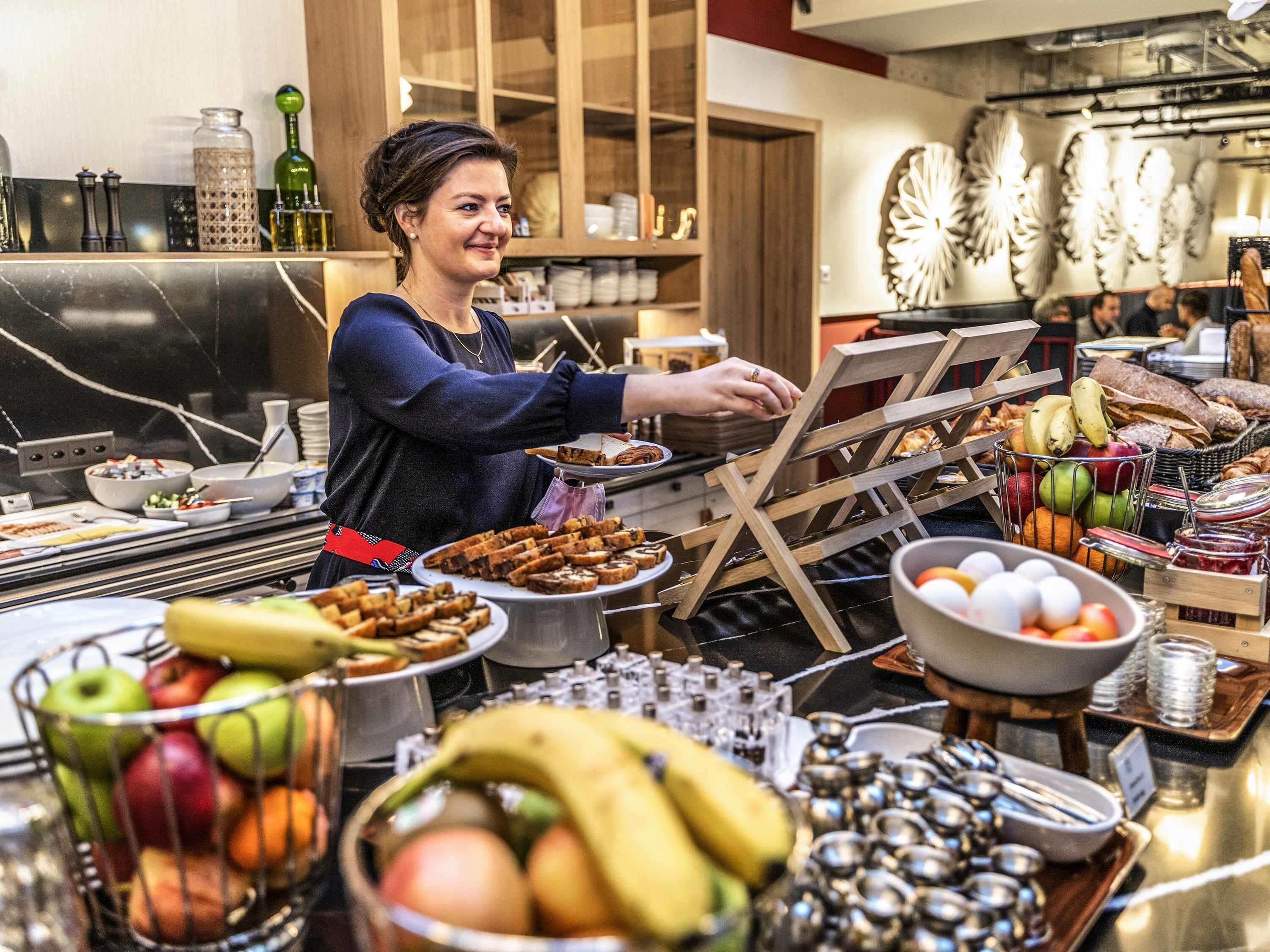 Ein reichhaltiges Buffet mit verschiedenen Speisen und einer Person, die bedient.