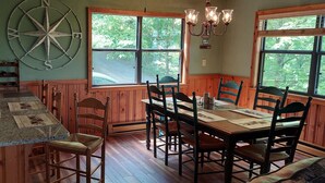 Un interior de madera con una encimera de cocina, una mesa de comedor y sillas.