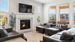 A modern living room with a fireplace, leather sofas, a flat-screen TV, and large windows. - Casa at Ladera Resort, Private Home! (Washington)