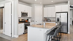 A modern kitchen with white cabinets, stainless steel appliances, a granite countertop, and a bar area with stools. - Casa at Ladera Resort, Private Home! (Washington)