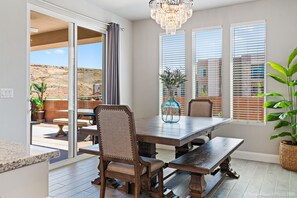 Un espace repas comprenant une grande table, des chaises et un lustre.