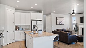 A modern kitchen with white cabinets, a granite countertop, and a built-in island with a sink. - Casa at Ladera Resort, Private Home! (Washington)