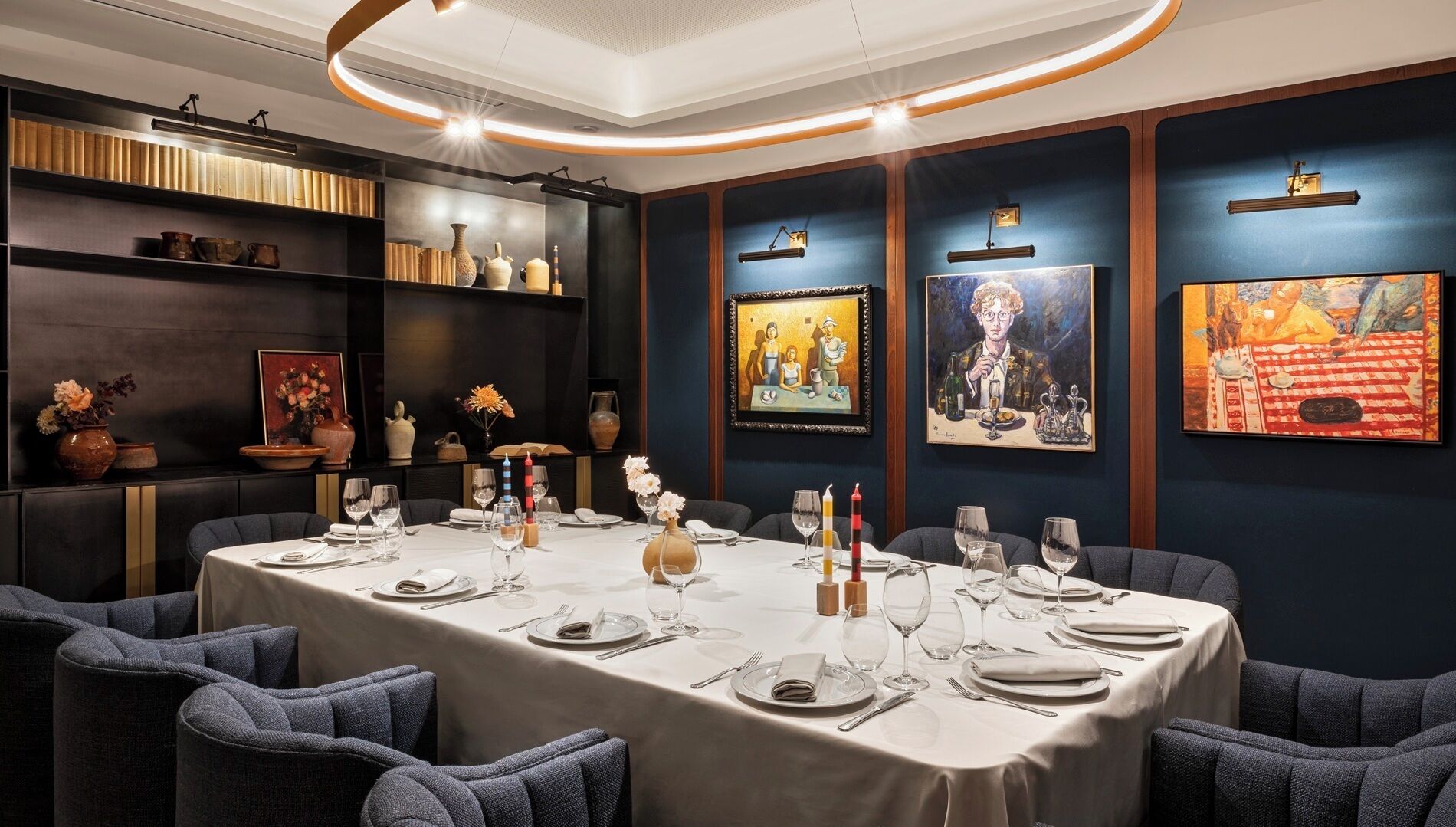Una sala menjador amb una taula llarga ben a punt per a dinar, envoltada de cadires.