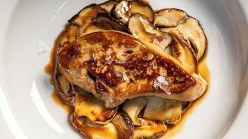 A plate of grilled chicken breast with mushrooms and sauce.