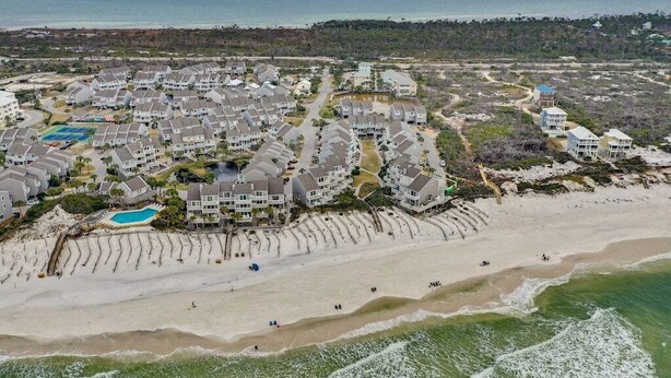 Eine Wohngegend an der Küste mit Häusern direkt am Strand, einem Schwimmbad und einem Strand.