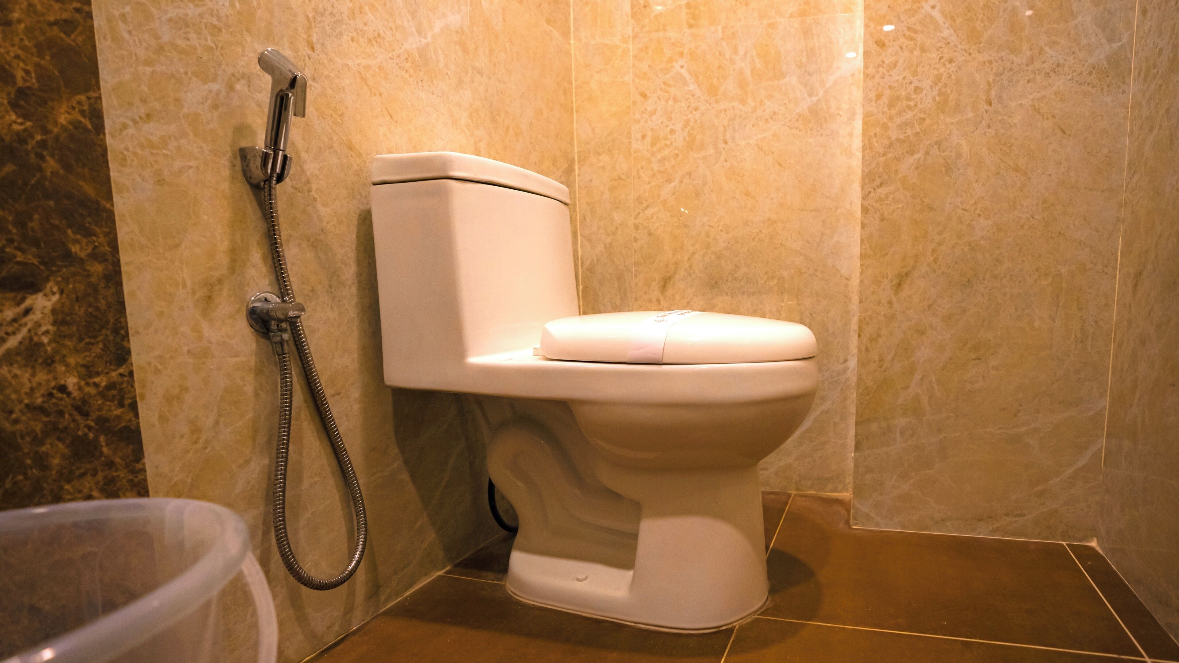 Une salle de bain équipée de toilettes, d’une douche et d’une poubelle.