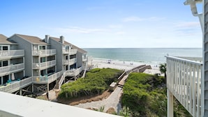 Un hôtel situé en bord de mer, doté de nombreux balcons, d’une plage de sable et offrant une vue dégagée sur l’océan.