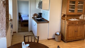 A compact kitchen with a microwave, coffee maker, and a wooden cabinet with glass doors. - Vacation at the winery (Maring-Noviand)
