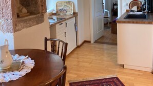 A cozy kitchen with a wooden table, chairs, and a patterned rug. - Vacation at the winery (Maring-Noviand)