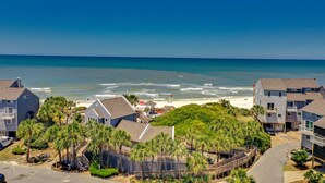 Una zona residencial costera con casas, una playa y un cielo azul despejado.