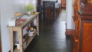A hallway with a wooden table, books, and a sign that reads "STAY awhile". - Two Hearts Rambling Rose (Hermann)