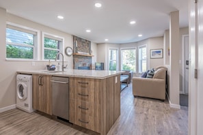 Enjoy cooking and relaxing in this well-lit kitchen with a large island, sink, and washer/dryer.