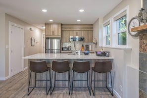 Enjoy cooking in this well-lit kitchen with a central island, bar stools, and ample counter space.