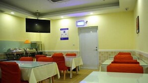 A dining area with tables and chairs, a television, and a door.