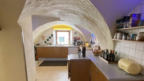 Una cocina con techo abovedado, una isla central y un tapete estampado.