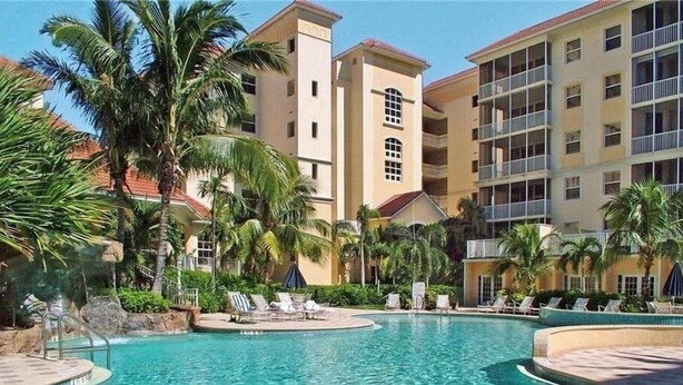 A resort pool surrounded by palm trees and a multi-story building with balconies. - Regatta Resort, Vanderbilt Beach, Naples, 6 minute walk to beach (Naples)