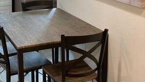 A dining area with a wooden table and chairs, a white wall, and a large picture of a bridge over water. - Hidden WineCountry Gem 1 Downstairs Unit (Santa Rosa)