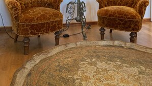 Due poltrone rivestite in tessuto animalier, una lampada da terra con un paralume color beige e un tappeto decorato su un pavimento in legno.
