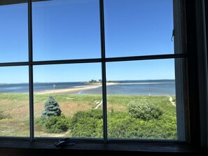 A window with a view of a beach and ocean.