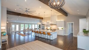 A spacious kitchen with a large island, modern pendant lights, and a ceiling fan. - Lakefront Home! Game Tables and Boat Dock (Hendersonville)