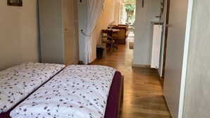 A narrow hallway with a bed on the left and a desk area on the right. - Kristallzimmer - Urlaub auf dem Historischen Weingut (Maring-Noviand)