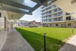 A modern building with a courtyard, a covered walkway, and a view of surrounding buildings.