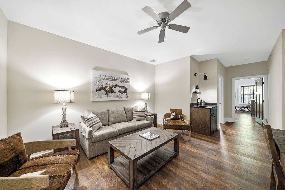 A living room with a sofa, coffee table, and a ceiling fan.