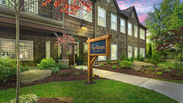 A two-story stone building with a sign reading "The Manor."